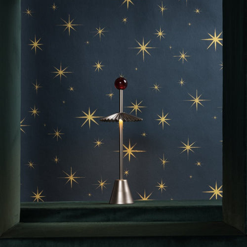 Decorative item resembling a star or celestial object against a starry night sky background.
