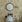 Room interior with floral wallpaper, round mirror, desk, chair, and digital clock.